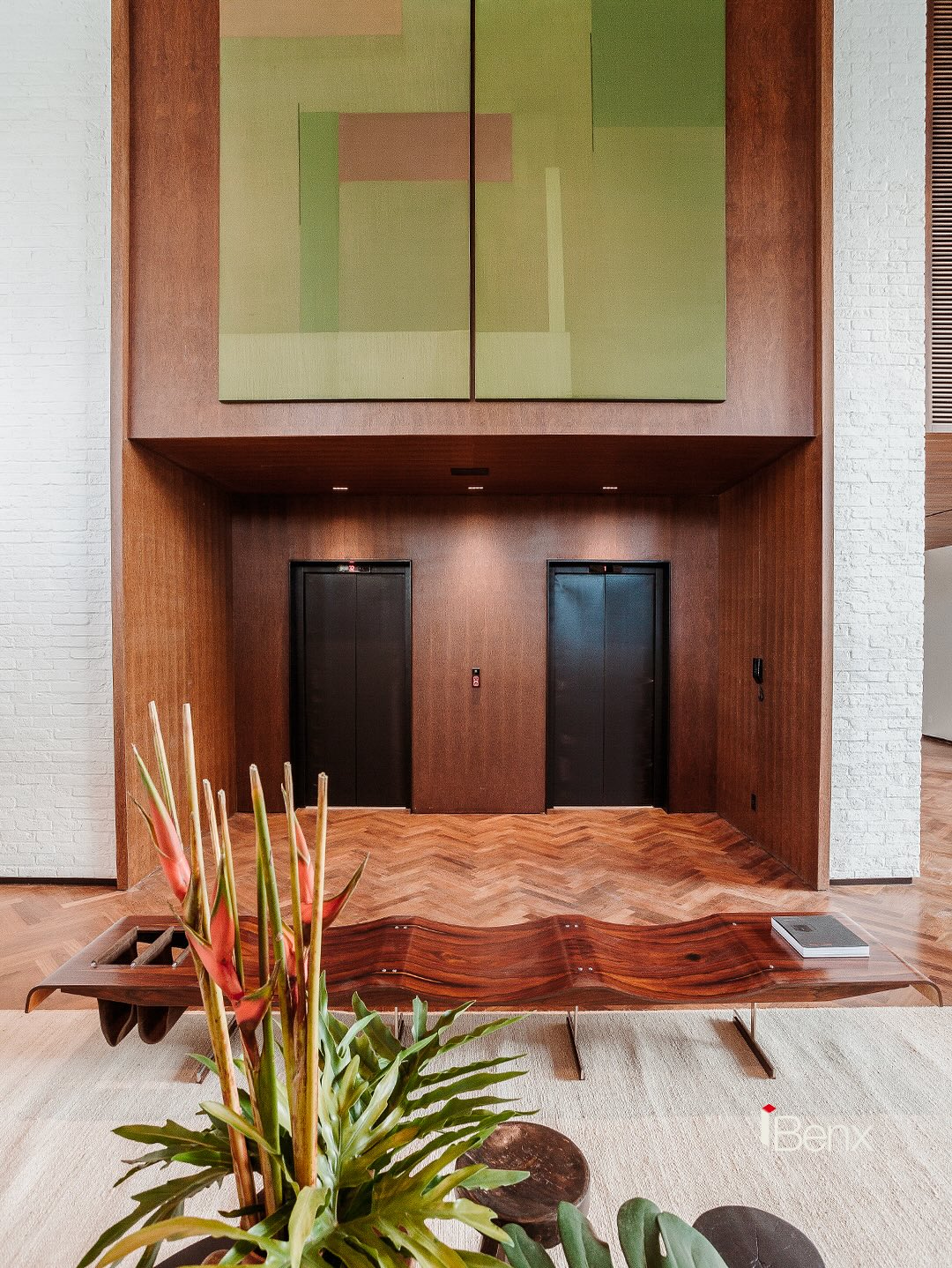 Lobby do Arborea Itaim com piso de madeira e lambril